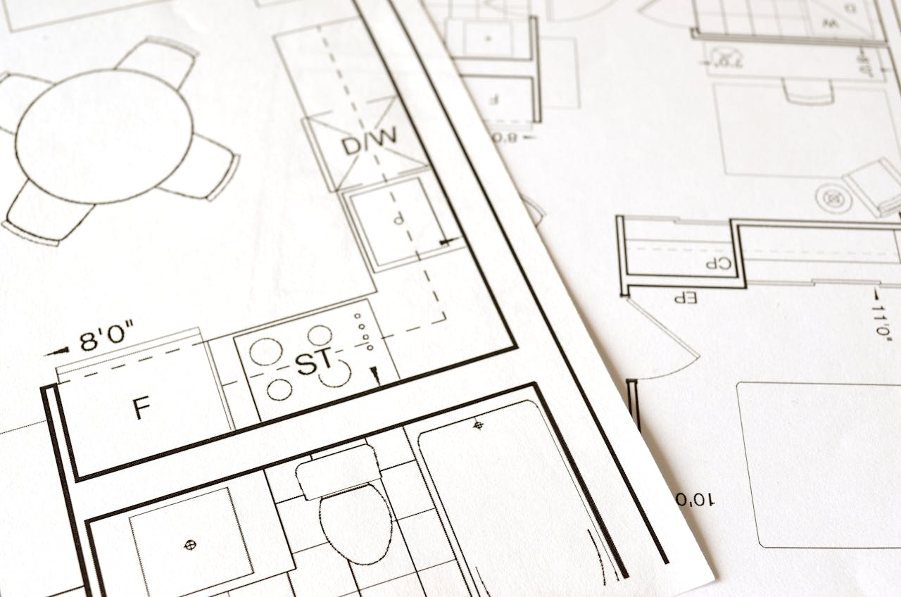 about-us Close-up view of an architectural floor plan on paper showcasing detailed room layouts and measurements.